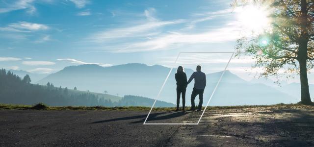 Silhouette of couple looking over mountain valley